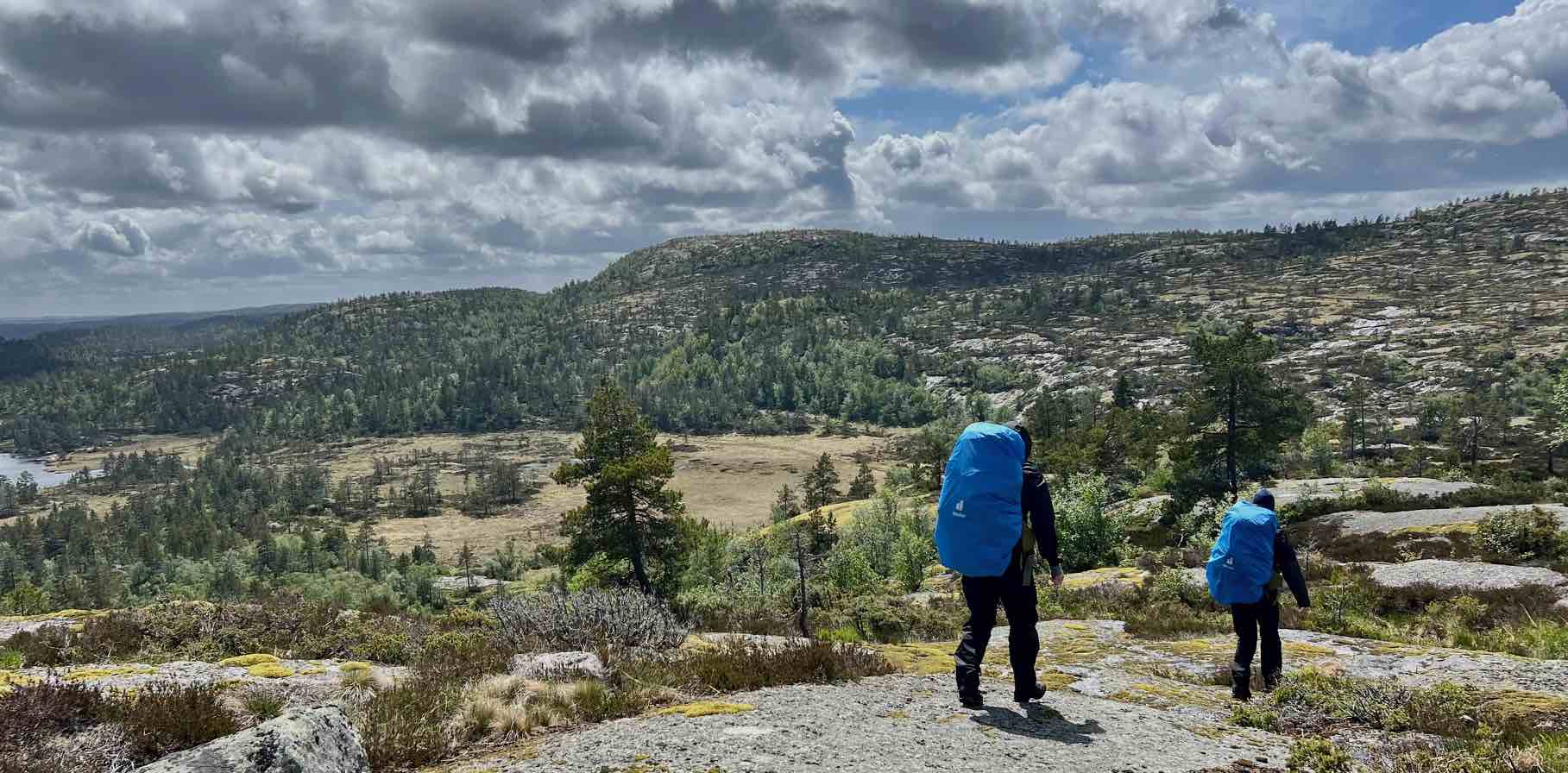 Twee wandelaars met rugzak op een rotsplateau in Zuid-Noorwegen