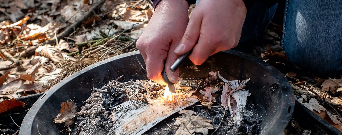 Vuur maken met een firesteel in een vuurschaal